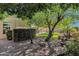 Serene backyard with meticulous landscaping, mature trees, and a decorative water feature at 3202 W Knudsen Dr, Phoenix, AZ 85027