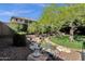 Serene backyard with a natural rock water feature, mature landscaping, and well-maintained lawn at 3202 W Knudsen Dr, Phoenix, AZ 85027