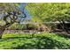 Lush backyard featuring verdant grass, mature trees, rock features, and a tranquil waterfall at 3202 W Knudsen Dr, Phoenix, AZ 85027