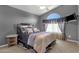 Comfortable bedroom with vaulted ceiling features a bed with decorative pillows and wall-mounted TV at 3202 W Knudsen Dr, Phoenix, AZ 85027