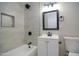 Bright bathroom featuring tiled shower with niche, modern vanity, and updated matte black fixtures at 3249 E Sunnyside Ln, Phoenix, AZ 85032