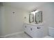 Bright bathroom featuring double sink vanity, modern mirrors, and updated matte black fixtures at 3249 E Sunnyside Ln, Phoenix, AZ 85032