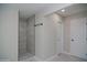 Bright bathroom featuring glass shower, neutral tiling, and door to the side at 3249 E Sunnyside Ln, Phoenix, AZ 85032