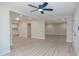 Open-concept living space with modern ceiling fan, light gray walls, and wood-look floors offers a versatile living area at 3249 E Sunnyside Ln, Phoenix, AZ 85032
