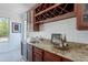 Custom wet bar with beautiful granite countertop and sleek cabinetry, complete with a wine fridge at 3574 E Glacier Pl, Chandler, AZ 85249