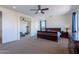 Well-lit bedroom featuring carpet floors, a ceiling fan, and access to additional rooms for versatile living at 3574 E Glacier Pl, Chandler, AZ 85249