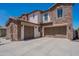 Three-car garages with a private drive and a stone-accented exterior at 3574 E Glacier Pl, Chandler, AZ 85249