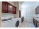 Laundry room with dark wood cabinets, tile floors and washer and dryer at 3574 E Glacier Pl, Chandler, AZ 85249