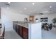 Open-concept living room with stone countertop bar and adjacent seating area; great for entertaining at 3574 E Glacier Pl, Chandler, AZ 85249