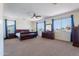 Spacious bedroom boasts large windows with neighborhood views, carpet, and classic wooden furniture set at 3574 E Glacier Pl, Chandler, AZ 85249