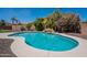 Sparkling pool with rock waterfall feature surrounded by lush landscaping and a privacy fence at 3574 E Glacier Pl, Chandler, AZ 85249