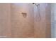 Inviting bathroom with tiled walls and floors, a niche with amenities, and a rainfall showerhead at 3574 E Glacier Pl, Chandler, AZ 85249