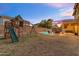 Spacious backyard featuring a playset, pool, and covered patio for outdoor entertainment at 4093 E Dublin St, Gilbert, AZ 85295