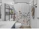 Bathroom with decorative shower curtain, shelving, and a sink; a blend of style and functionality at 4093 E Dublin St, Gilbert, AZ 85295