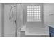 Bathroom featuring a bathtub with glass block window and separate shower at 4093 E Dublin St, Gilbert, AZ 85295