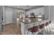 Spacious kitchen featuring a breakfast bar area with seating, white cabinetry, and modern lighting at 4093 E Dublin St, Gilbert, AZ 85295