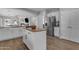 Well-lit kitchen with an island, stainless steel refrigerator, white cabinetry, and laminate countertops at 4093 E Dublin St, Gilbert, AZ 85295