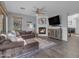 Cozy living room with a fireplace, comfortable sectional sofa, and a ceiling fan at 4093 E Dublin St, Gilbert, AZ 85295