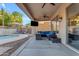 Covered patio features a tv, ceiling fans and a seating area with a view of the pool at 4093 E Dublin St, Gilbert, AZ 85295