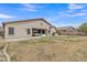 Expansive backyard with patio, lush lawn, and a decorative sun emblem on the home's exterior at 43271 W Little Dr, Maricopa, AZ 85138