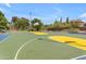 Outdoor basketball court features vibrant colors and is surrounded by trees and landscaping for a fun and active community space at 43271 W Little Dr, Maricopa, AZ 85138