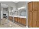 Bathroom featuring dual vanities, a large mirror, and wood cabinets at 43271 W Little Dr, Maricopa, AZ 85138