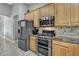 Close-up of kitchen appliances including a stainless steel refrigerator, microwave, and oven at 43271 W Little Dr, Maricopa, AZ 85138