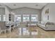 Bright living room with high ceilings, large windows, and a dining area with a long table set for entertaining at 43271 W Little Dr, Maricopa, AZ 85138