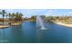 Beautiful waterfront view with a fountain on the pond and golf course in the background, surrounded by lush landscaping at 43271 W Little Dr, Maricopa, AZ 85138