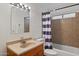 Cozy bathroom featuring a single sink vanity and a shower tub with a striped curtain at 4333 E Desert Cactus St, Phoenix, AZ 85032