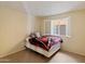 Bedroom showcasing bright natural light, a comfortable bed, and neutral-toned tile flooring at 4333 E Desert Cactus St, Phoenix, AZ 85032