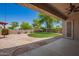 Well-maintained backyard features desert landscaping, green lawn and covered patio at 44574 W Garden Ln, Maricopa, AZ 85139