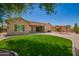Backyard features well-kept grass, desert landscaping, and a red pergola at 44574 W Garden Ln, Maricopa, AZ 85139