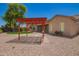 Backyard features gravel, desert landscaping, and a red pergola at 44574 W Garden Ln, Maricopa, AZ 85139