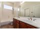 Bathroom featuring dual sinks, wood cabinets, tub, shower, and ample natural light at 44574 W Garden Ln, Maricopa, AZ 85139