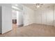 Spacious carpeted bedroom with ceiling fan, closet, and doorway view of kitchen at 44574 W Garden Ln, Maricopa, AZ 85139