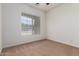 Bedroom with neutral carpet and a view to the exterior at 44574 W Garden Ln, Maricopa, AZ 85139