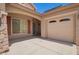 Close-up of home exterior showing garage, driveway, and tasteful stone accents at 44574 W Garden Ln, Maricopa, AZ 85139