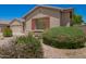Well-kept home with desert landscaping featuring shrubs and flowers, complemented by stylish shutters at 44574 W Garden Ln, Maricopa, AZ 85139