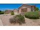 Well-kept home with desert landscaping featuring shrubs and flowers, complemented by stylish shutters at 44574 W Garden Ln, Maricopa, AZ 85139
