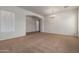 Spacious living room with carpet and chandelier, showcasing an arched doorway at 44574 W Garden Ln, Maricopa, AZ 85139