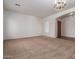 Expansive living room featuring plush carpeting, neutral walls, and elegant chandelier lighting at 44574 W Garden Ln, Maricopa, AZ 85139