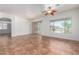 Open-concept living space with tile flooring, ceiling fan and sliding door to backyard at 44574 W Garden Ln, Maricopa, AZ 85139