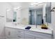 Dual sink bathroom vanity with quartz countertop, sleek fixtures, and a large mirror offering ample space at 512 S Soho Ln # 8, Chandler, AZ 85225