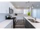 Bright kitchen featuring white cabinetry, stainless steel appliances, a spacious island with sink, and modern lighting at 512 S Soho Ln # 8, Chandler, AZ 85225