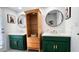 Bathroom featuring double sinks, green cabinetry, and stylish round mirrors at 5309 W Dahlia Dr, Glendale, AZ 85304