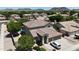 Aerial view of the home featuring a tile roof, multi-car garage, desert landscaping, and mountain views at 6030 W Topeka Dr, Glendale, AZ 85308