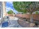 Spacious backyard with gravel landscaping, sidewalk, and mature tree providing shade at 6030 W Topeka Dr, Glendale, AZ 85308