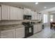 Well-equipped kitchen with black appliances, granite countertops and white cabinetry at 6030 W Topeka Dr, Glendale, AZ 85308