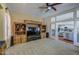 Spacious living room featuring a large entertainment center, ceiling fan and access to another living area at 6030 W Topeka Dr, Glendale, AZ 85308